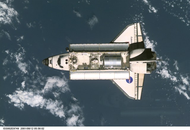 View of the Space Shuttle Discovery as it approaches the International Space Station (ISS) during the STS-105 mission. Aboard Discovery are the members of the Expedition Three crew - Frank L. Culbertson, Jr., mission commander, and cosmonauts Vladimir N. Dezhurov and Mikhail Tyurin, flight engineers - who will be replacing the Expedition Two crew that has been living on the ISS for the past five months. Visible in the payload bay of Discovery are the Multipurpose Logistics Module (MPLM) Leonardo, which stores various supplies and experiments to be transferred into the ISS; and the Integrated Cargo Carrier (ICC) which carries the Early Ammonia Servicer (EAS) and two Materials International Space Station Experiment (MISSE) containers. This image was taken with a digital still camera.