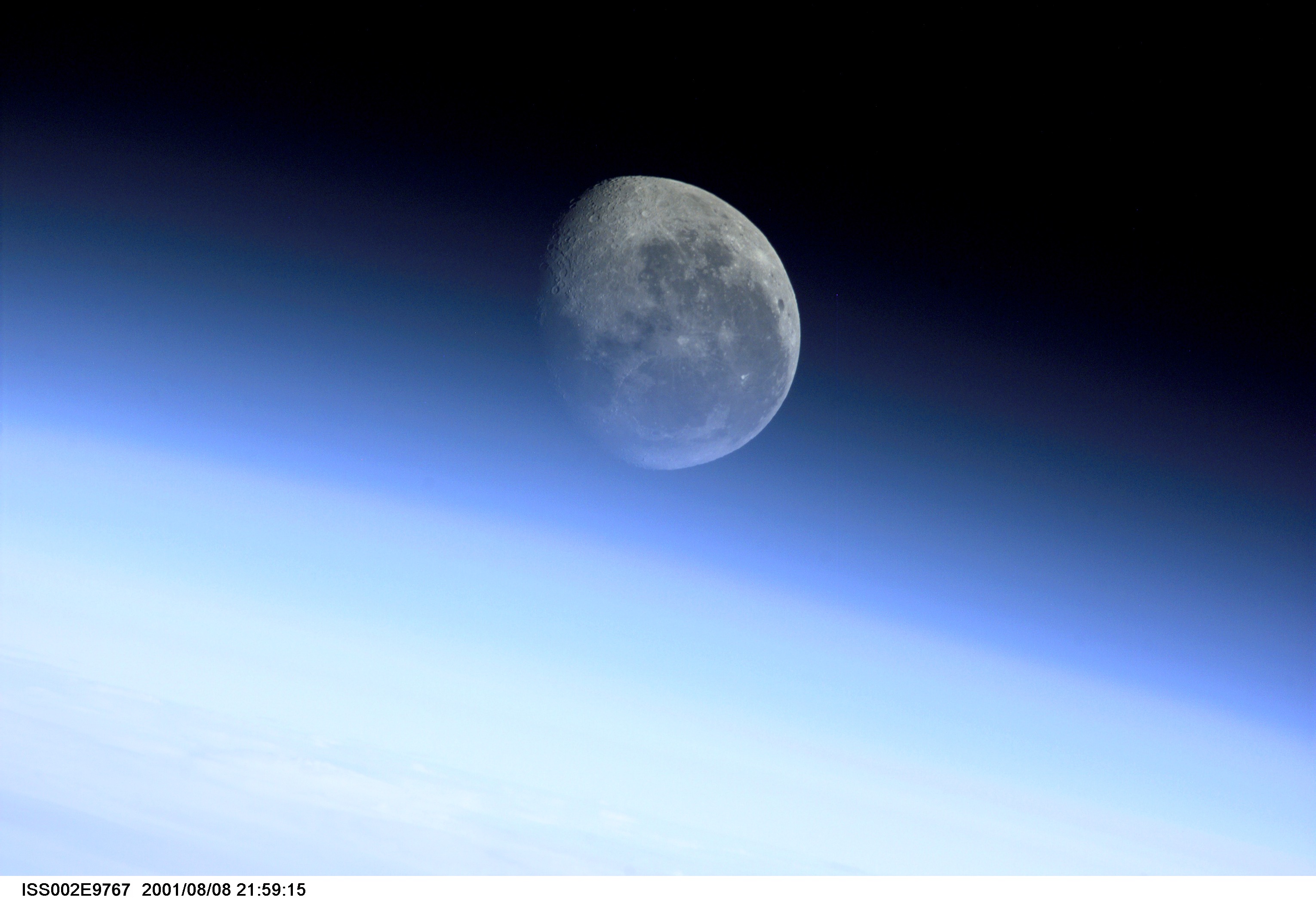 This image, recorded with a digital still camera by one of the Expedition Two crew members onboard the International Space Station, is a glimpse of the barren moon through the Earth's limb. With no atmosphere, and therefore no limb of its own, the edge of the moon arcs crisply against the backdrop of space. Some of the most breathtaking views of Earth taken from space are those that capture our planet's limb. When viewed from the side, the Earth looks like a flat circle, and the atmosphere appears like a halo around it. This glowing halo is known as the limb. Viewed from satellites, space shuttles, and even the moon, the image of this luminous envelope of gases shielding the life on our planet from the dark, cold space beyond rarely fails to fascinate us.