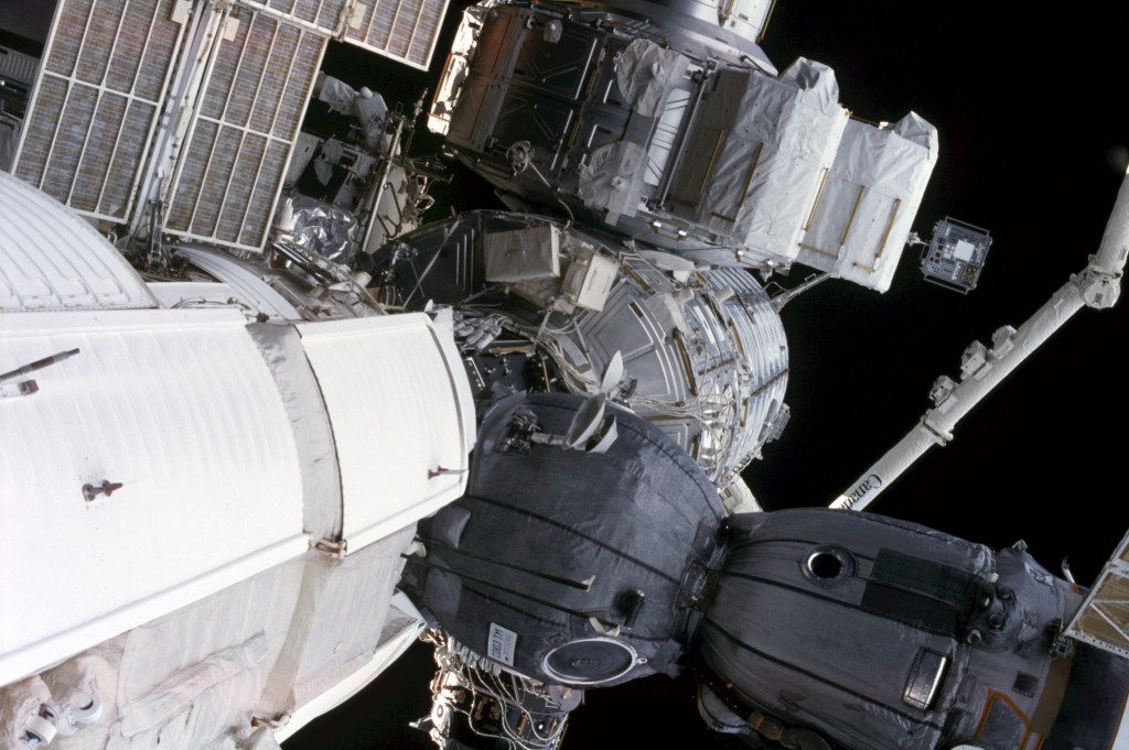 This close-up view of the International Space Station (ISS), backdropped by the blackness of space, shows a Soyuz spacecraft docked to the orbital outpost.