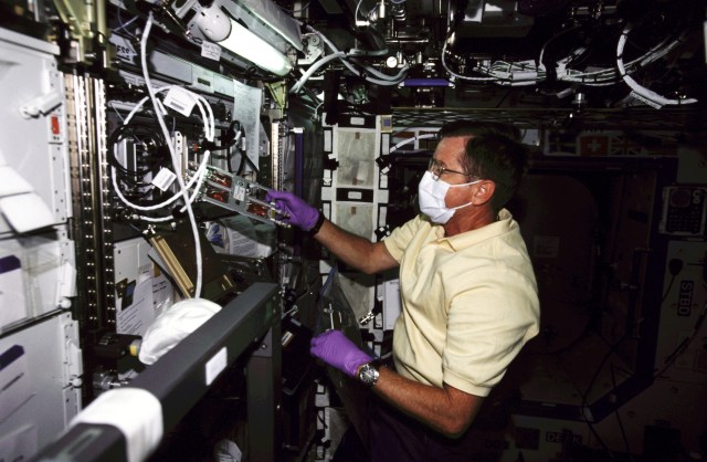 Astronaut Frank L. Culbertson, Jr., Expedition Three mission commander, works at the Biotechnology Specimen Temperature Controller (BSTC) for the Cellular Biotechnology Operations Support System (CBOSS) in the Destiny laboratory on the International Space Station (ISS).