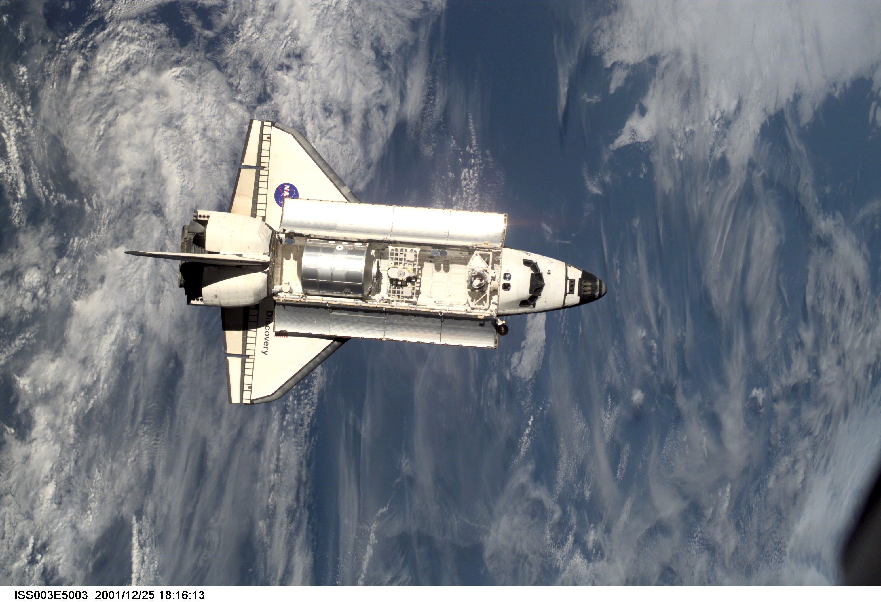 The Space Shuttle Discovery approaches the International Space Station (ISS) during the STS-105 mission. Aboard Discovery are the members of the Ex...