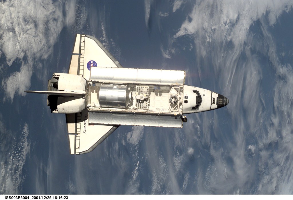 The Space Shuttle Discovery approaches the International Space Station (ISS) during the STS-105 mission. Aboard Discovery are the members of the Expedition Three crew -- Frank L. Culbertson, mission commander, and cosmonauts Vladimir N. Dezhurov and Mikhail Tyurin, flight engineers -- who will be replacing the Expedition Two crew that has been living on the ISS for the past five months. This image was taken by an Expedition Two crew member with a digital still camera.