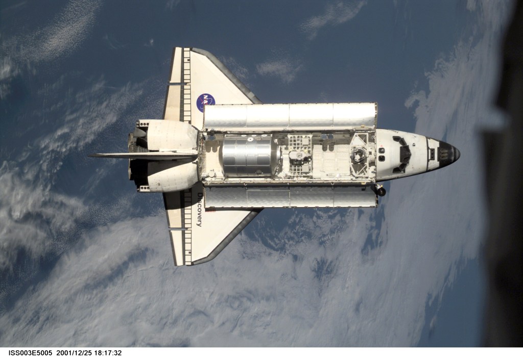 The Space Shuttle Discovery approaches the International Space Station (ISS) during the STS-105 mission. Aboard Discovery are the members of the Expedition Three crew -- Frank L. Culbertson, mission commander, and cosmonauts Vladimir N. Dezhurov and Mikhail Tyurin, flight engineers -- who will be replacing the Expedition Two crew that has been living on the ISS for the past five months. This image was taken by an Expedition Two crew member with a digital still camera.