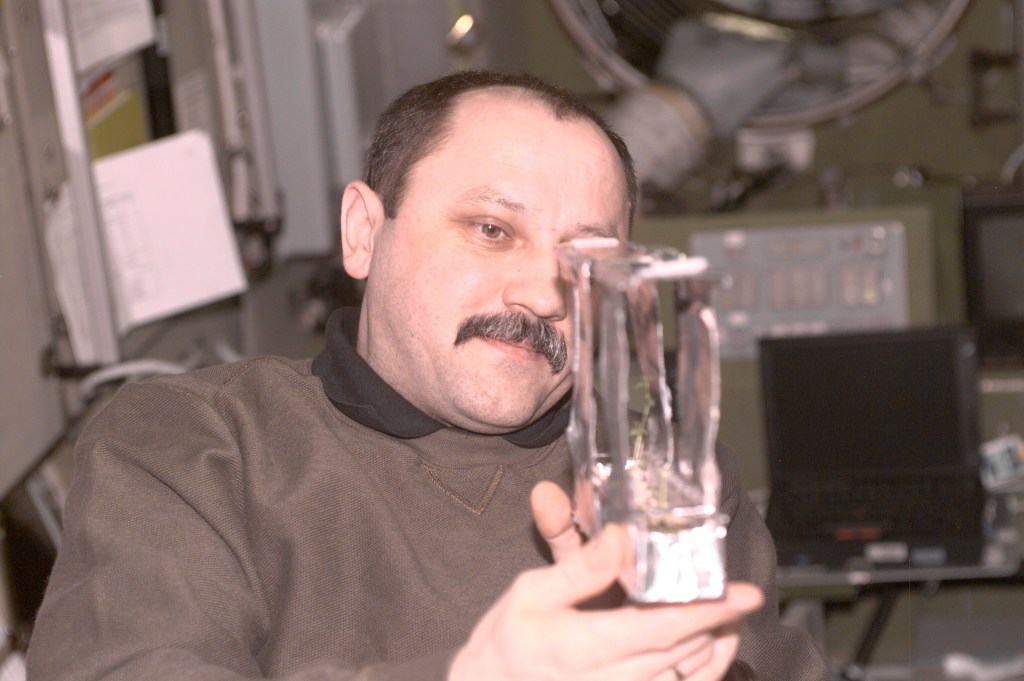 Yury V. Usachev of Rosaviakosmos, Expedition Two mission commander, examines a plant experiment in the Zvezda Service Module. This image was taken with a digital still camera.