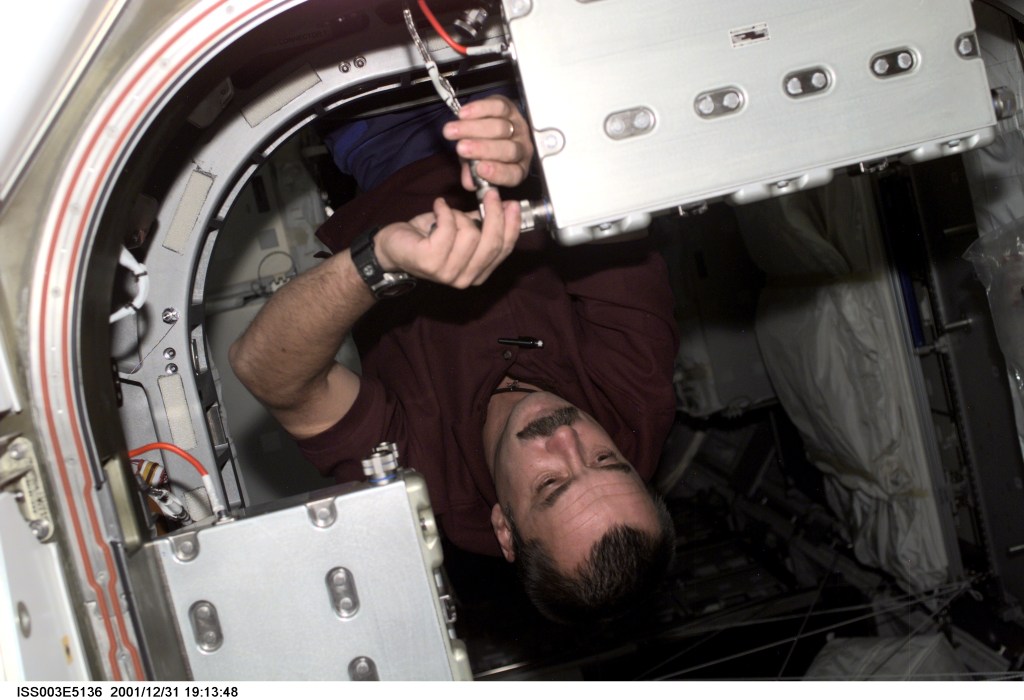 Mikhail Tyurin of Rosaviakosmos, Expedition Three flight engineer, secures a connection on a Controller Power Assembly (CPA) in a hatchway on Unity Node 1. This image was taken with a digital still camera.