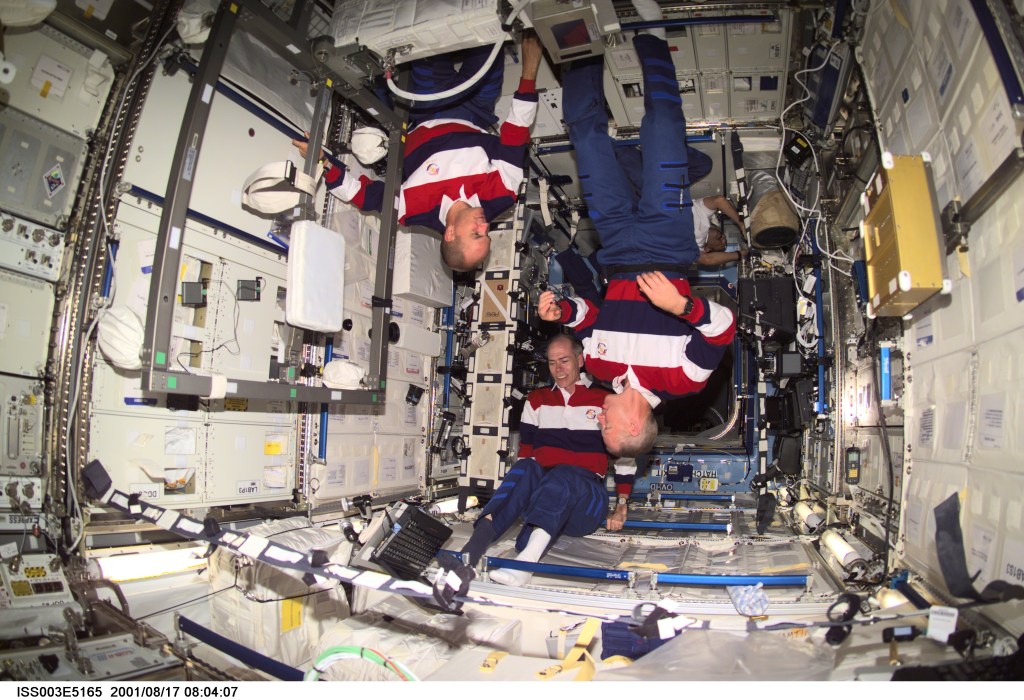 Astronauts Frederick W. (Rick) Sturckow (left), STS-105 pilot, Daniel T. Barry and Patrick G. Forrester, both mission specialists, work on various tasks in the Destiny laboratory on the International Space Station (ISS). This image was taken with a digital still camera.