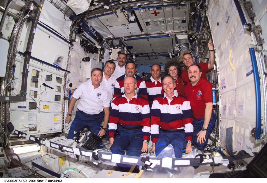 The Expedition Three (white shirts), STS-105 (striped shirts), and Expedition Two (red shirts) crews assemble for a group photo in the Destiny laboratory on the International Space Station (ISS). The Expedition Three crew members are, from front to back, Frank L. Culbertson, Jr., mission commander; and cosmonauts Vladimir N. Dezhurov and Mikhail Tyurin, flight engineers; STS-105 crew members are, front row, Patrick G. Forrester and Daniel T. Barry, mission specialists, and back row, Scott J. Horowitz, commander, and Frederick W. (Rick) Sturckow, pilot; Expedition Two crew members are, from front to back, cosmonaut Yury V. Usachev, mission commander, James S. Voss and Susan J. Helms, flight engineers. Dezhurov, Tyurin and Usachev represent Rosaviakosmos. This image was taken with a digital still camera.