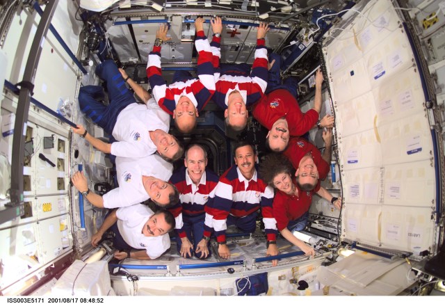 The Expedition Three (white shirts), STS-105 (striped shirts), and Expedition Two (red shirts) crews assemble for a group photo in the Destiny laboratory on the International Space Station (ISS). The Expedition Three crew members are, from bottom to top, cosmonauts Mikhail Tyurin and Vladimir N. Dezhurov, both flight engineers, and Frank L. Culbertson, Jr., mission commander; STS-105 crew members are, front row, Daniel T. Barry, mission specialist, and Scott J. Horowitz, commander, back row, Frederick W. (Rick) Sturckow, pilot, and Patrick G. Forrester, mission specialist; Expedition Two crew members are, from top to bottom, cosmonaut Yury V. Usachev, mission commander, James S. Voss and Susan J. Helms, flight engineers. Dezhurov, Tyurin and Usachev represent Rosaviakosmos. This image was taken with a digital still camera.