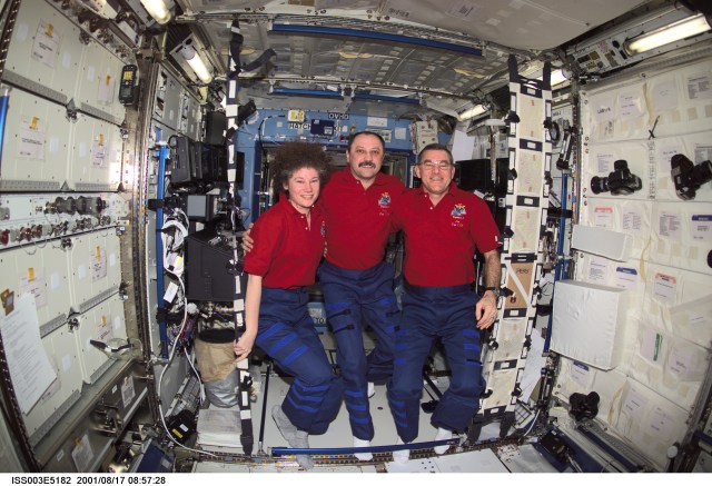 The Expedition Two crew members pause from their daily activities to pose for a group photo in the Destiny laboratory on the International Space Station (ISS). From left to right are, astronaut Susan J. Helms, flight engineer, cosmonaut Yury V. Usachev, mission commander, and astronaut James S. Voss, flight engineer. Usachev represents Rosaviakosmos. This image was taken with a digital still camera.