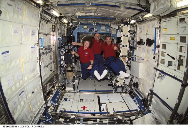 The Expedition Two crew members pause from their daily activities to pose for a group photo in the Destiny laboratory while visiting the International Space Station (ISS). From left to right are, astronaut Susan J. Helms, flight engineer, cosmonaut Yury V. Usachev, mission commander, and astronaut James S. Voss, flight engineer. Usachev represents Rosaviakosmos. This image was taken with a digital still camera.