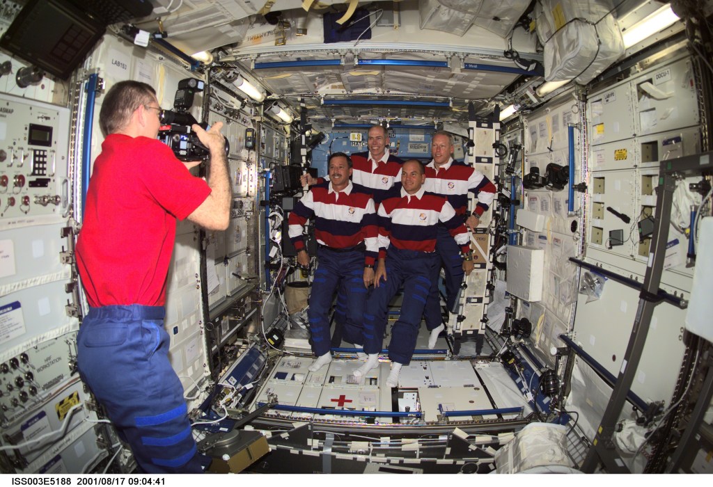 Astronaut James S. Voss, Expedition Two flight engineer, photographs astronauts Scott J. Horowitz (front left), STS-105 mission commander, Frederick W. (Rick) Sturckow, pilot, Daniel T. Barry (back left), and Patrick G. Forrester, both mission specialists, in the Destiny laboratory on the International Space Station (ISS). This image was taken with a digital still camera.