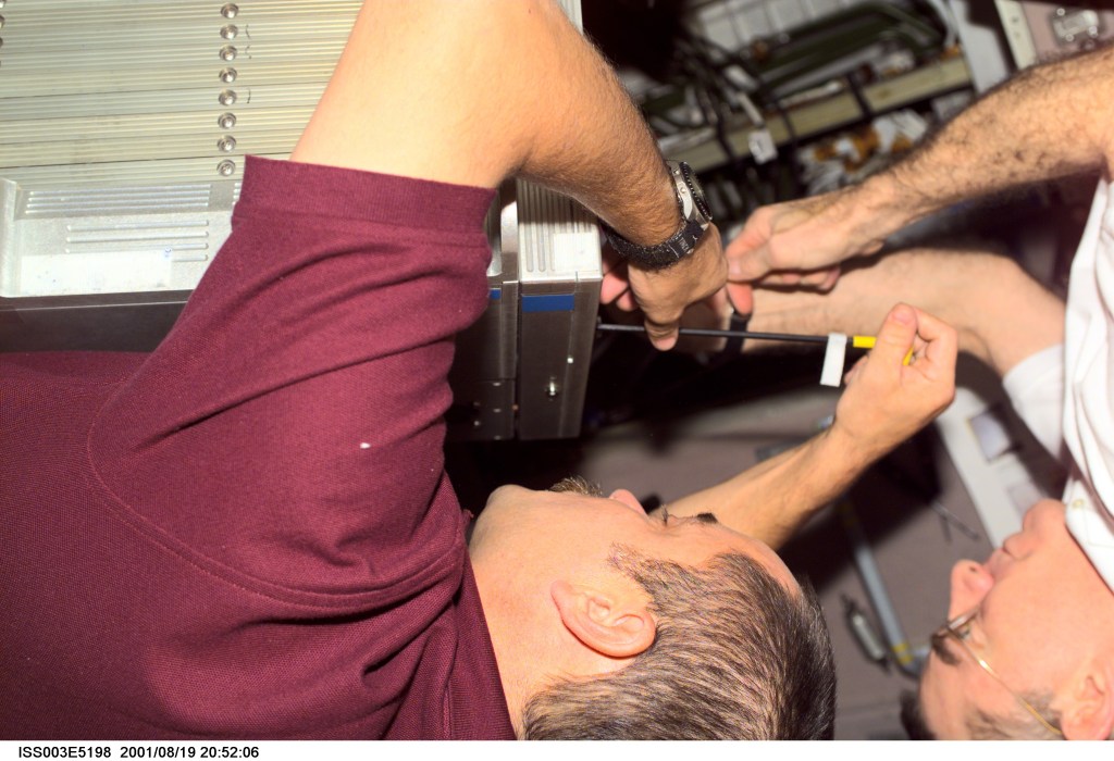 Cosmonaut Mikhail Tyurin (left), Expedition Three flight engineer representing Rosaviakosmos, and astronaut James S. Voss, Expedition Two flight engineer, perform maintenance in the Zvezda Service Module on the International Space Station (ISS). This image was taken with a digital still camera.