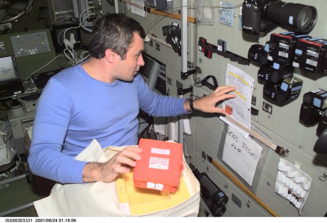 Cosmonaut Vladimir N. Dezhurov, flight engineer representing Rosaviakosmos, checks over a list of procedures in the Zvezda Service Module on the International Space Station (ISS). This image was taken with a digital still camera.