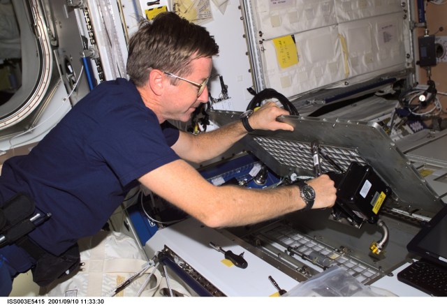 Expedition Three mission commander Frank L. Culbertson, Jr., conducts inflight maintenance with a ratchet under a panel in the Unity Node 1 on the International Space Station (ISS). This image was taken with a digital still camera.