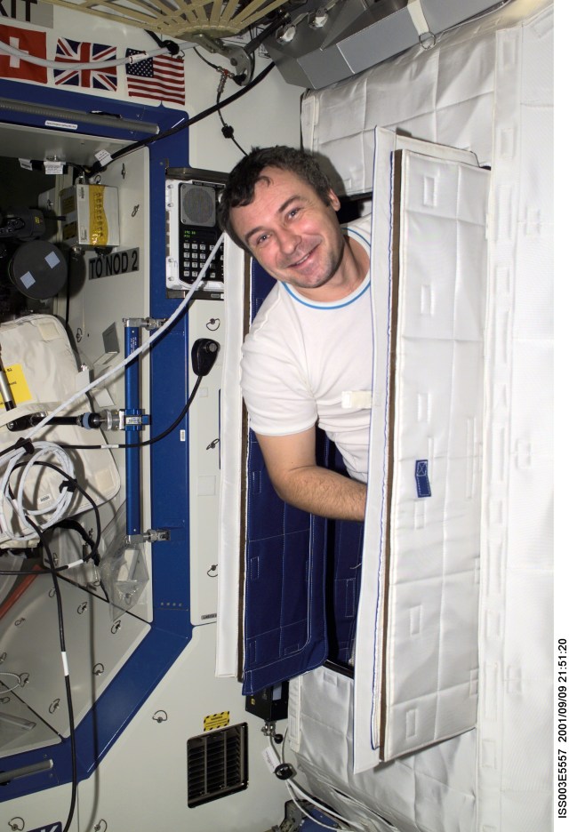 Cosmonaut Vladimir Dezhurov of Rosaviakosmos, Expedition Three flight engineer, pokes his head out of the Temporary Sleep Station (TSS) in the U.S. Laboratory.