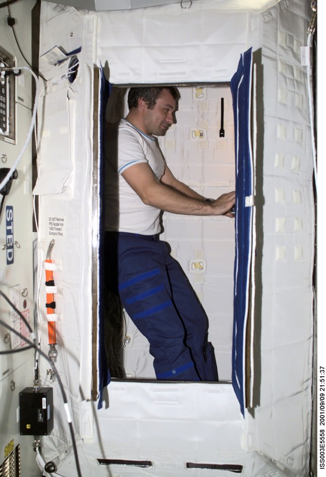 Cosmonaut Vladimir Dezhurov of Rosaviakosmos, Expedition Three flight engineer, works on a laptop computer in the Temporary Sleep Station (TSS) in the U.S. Laboratory.