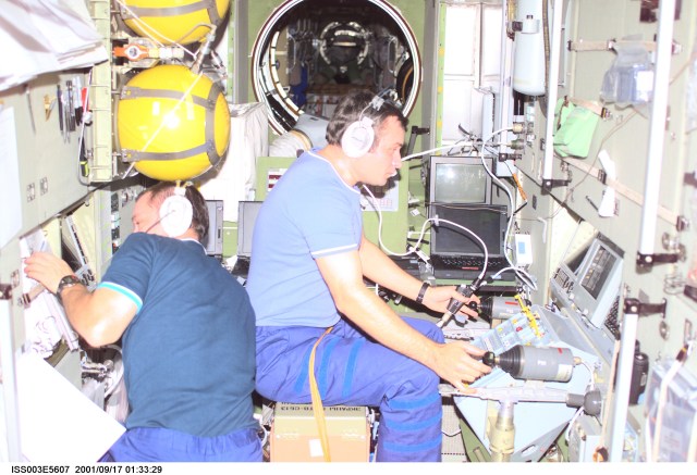 Cosmonaut Mikhail Tyurin (left) reads a monitor while cosmonaut Vladimir Dezhurov works at the Simvol-Ts workstation in the Zvezda Service Module. Tyurin and Dezhurov are Expedition Three flight engineers and represent Rosaviakosmos.
