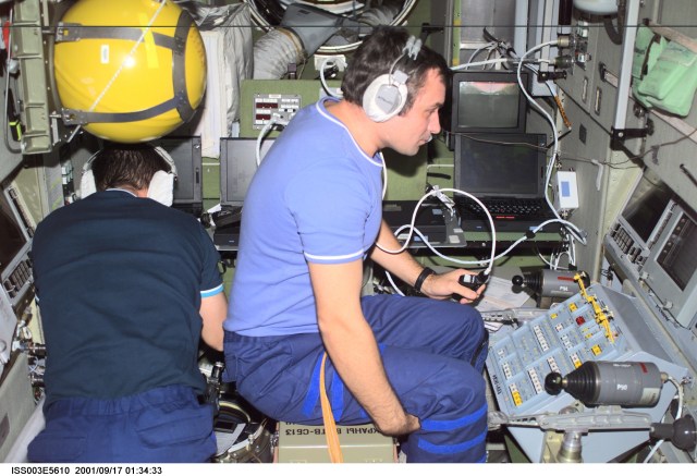 ISS003-E-5610 (17 September 2001) --- Cosmonaut Mikhail Tyurin (left) works with a laptop computer while cosmonaut Vladimir Dezhurov works at the Simvol-Ts workstation in the Zvezda Service Module. Tyurin and Dezhurov are Expedition Three flight engineers and represent Rosaviakosmos
