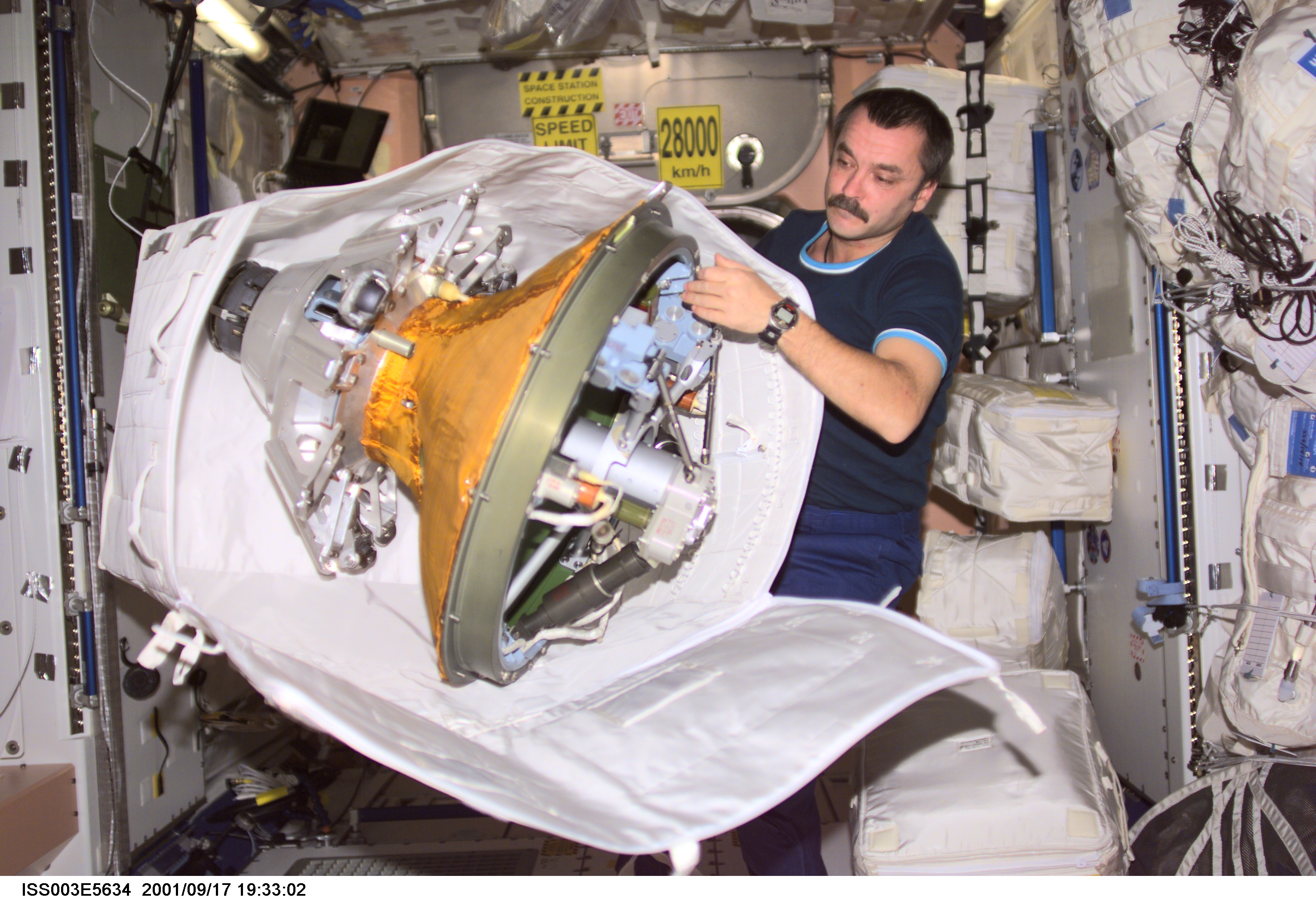 Cosmonaut Mikhail Tyurin, Expedition Three flight engineer, packs the docking probe in a stowage bag in Unity. The docking probe successfully guided the arrival of the Russian-built Pirs docking compartment to the International Space Station (ISS). Tyurin represents Rosaviakosmos.