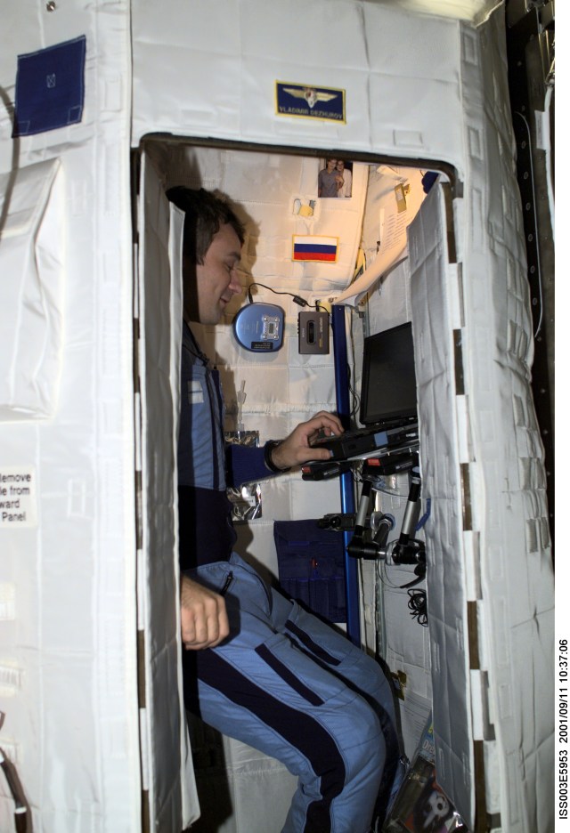 Cosmonaut Vladimir N. Dezhurov, Expedition Three flight engineer, works on a laptop computer in the Temporary Sleep Station (TSS) in the Destiny laboratory on the International Space Station (ISS). Dezhurov represents Rosaviakosmos. This image was taken with a digital still camera.