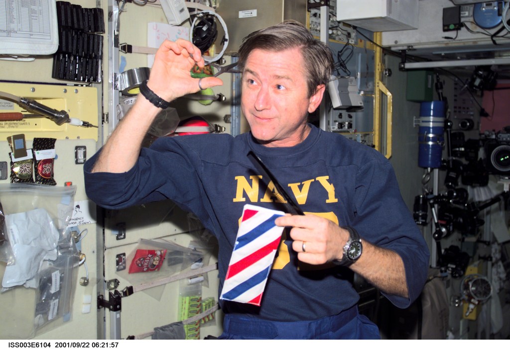 Astronaut Frank L. Culbertson, Jr., Expedition Three mission commander, cuts his hair in the Zvezda Service Module on the International Space Station (ISS). This picture was taken with a digital still camera.