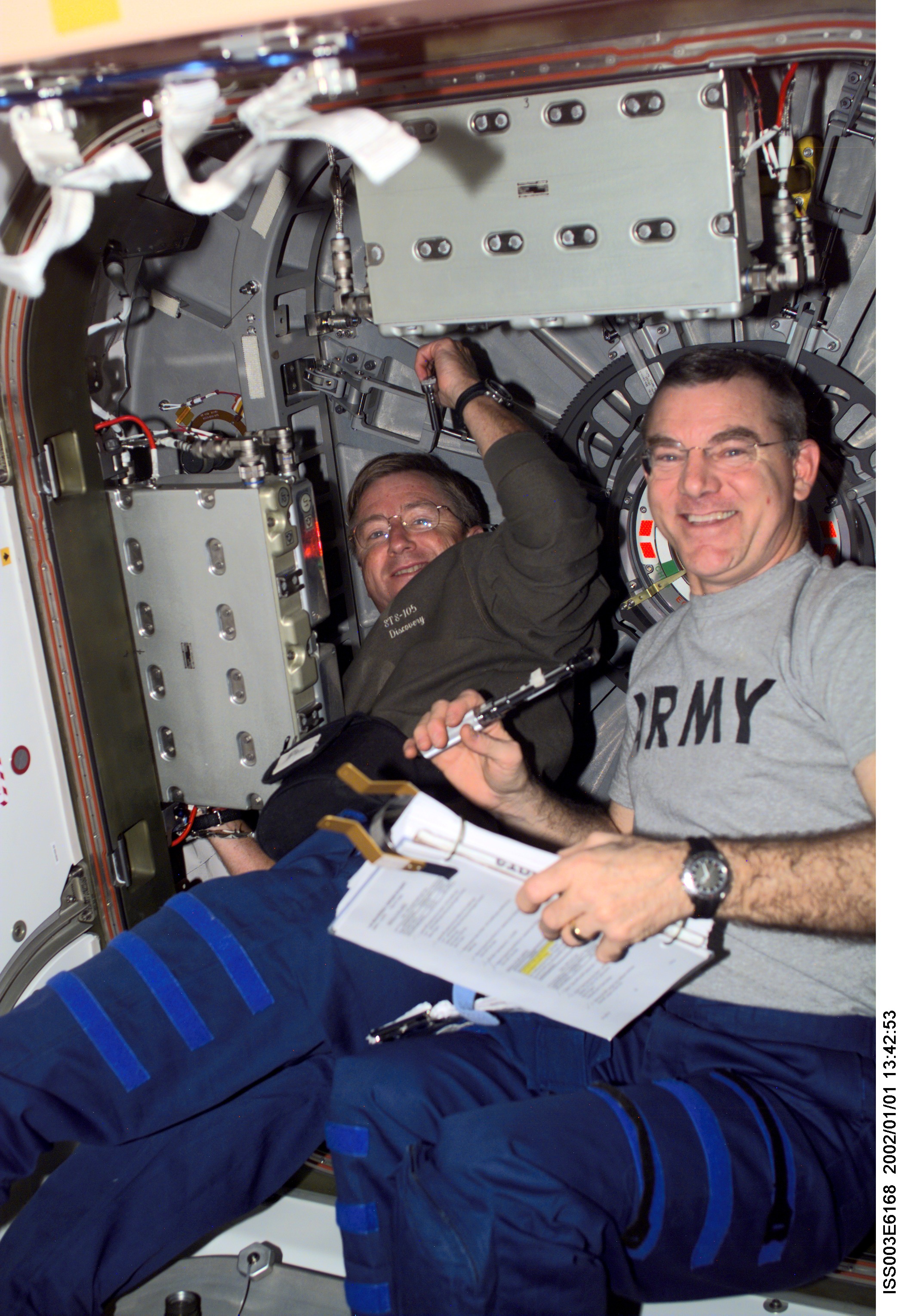 Astronauts Frank L. Culbertson, Jr., Expedition Three mission commander, and James S. Voss, Expedition Two flight engineer, perform routine tasks in the Unity node on the International Space Station (ISS). This image was taken with a digital still camera.