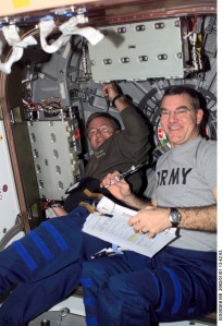 Astronauts Frank L. Culbertson, Jr., Expedition Three mission commander, and James S. Voss, Expedition Two flight engineer, perform routine tasks in the Unity node on the International Space Station (ISS). This image was taken with a digital still camera.