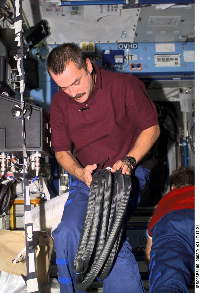 Cosmonaut Mikhail Tyurin, Expedition Three flight engineer representing Rosaviakosmos, works with cables in the Destiny laboratory on the International Space Station (ISS). This image was taken with a digital still camera.