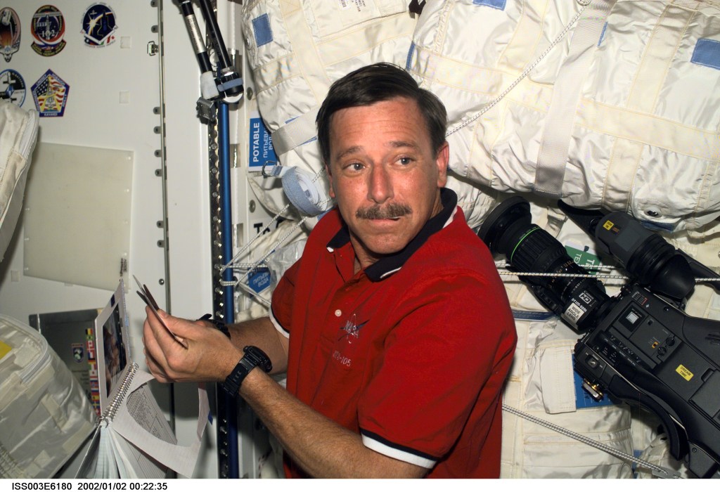 Astronaut Scott J. Horowitz, STS-105 mission commander, prepares the STS-105 crew patch to be added to the growing collection of those representing Shuttle crews who have worked on the International Space Station (ISS). Horowitz is located in the Unity node of the ISS. This image was taken with a digital still camera.