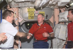Astronauts James S. Voss (left), Expedition Two flight engineer, Patrick G. Forrester, STS-105 mission specialist, and Scott J. Horowitz, mission commander, exchange greetings in the Unity node on the International Space Station (ISS). This image was taken with a digital still camera.