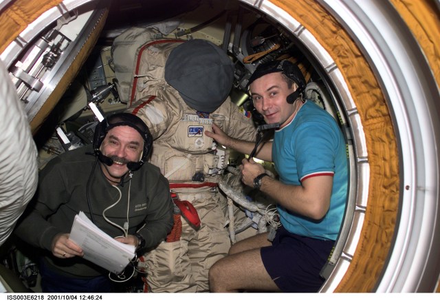 Cosmonauts Mikhail Tyurin (left) and Vladimir N. Dezhurov, both Expedition Three flight engineers, prepare the Russian Orlan space suit for an upcoming spacewalk from Pirs Docking Compartment on the International Space Station (ISS). Tyurin and Dezhurov represent Rosaviakosmos. This image was taken with a digital still camera.
