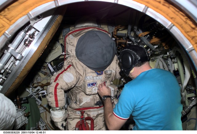 Cosmonaut Vladimir N. Dezhurov, Expedition Three flight engineer, prepares the Russian Orlan space suit for a spacewalk, scheduled later in the week from the Pirs Docking Compartment on the International Space Station (ISS). Dezhurov represents Rosaviakosmos. This image was taken with a digital still camera.