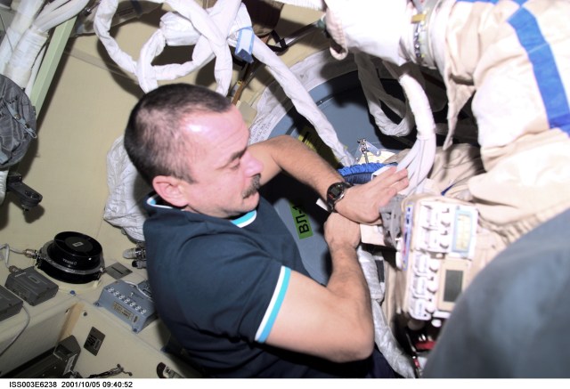 Cosmonaut Mikhail Tyurin, Expedition Three flight engineer, prepares the Russian Orlan space suit for an upcoming spacewalk from the Pirs Docking Compartment on the International Space Station (ISS). Tyurin represents Rosaviakosmos. This image was taken with a digital still camera.