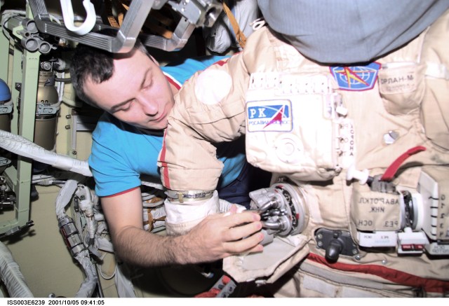 Cosmonaut Vladimir N. Dezhurov, Expedition Three flight engineer, prepares the Russian Orlan space suit for an upcoming spacewalk from the Pirs Docking Compartment on the International Space Station (ISS). Dezhurov represents Rosaviakosmos. This image was taken with a digital still camera.