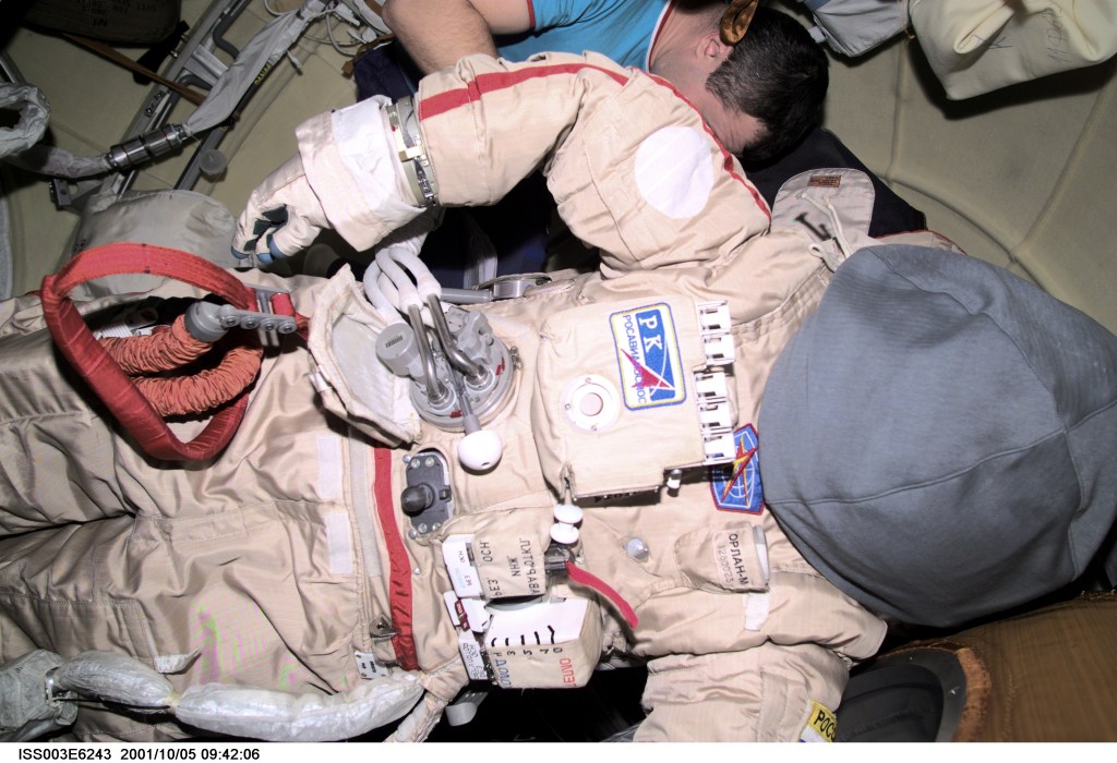 Cosmonaut Vladimir N. Dezhurov, Expedition Three flight engineer, prepares the Russian Orlan space suit for an upcoming spacewalk from the Pirs Docking Compartment on the International Space Station (ISS). Dezhurov represents Rosaviakosmos. This image was taken with a digital still camera.