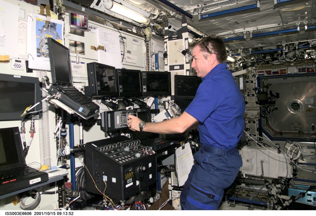 Astronaut Frank L. Culbertson, Jr., Expedition Three mission commander, works the controls of the Canadarm2, or Space Station Remote Manipulator System (SSRMS) in the Destiny laboratory on the International Space Station (ISS). This image was taken with a digital still camera.
