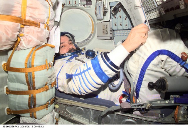 Cosmonaut Mikhail Tyurin, Expedition Three flight engineer, wearing a Russian Sokol suit, is seated in the Soyuz spacecraft that is docked to the International Space Station (ISS). This Soyuz return vehicle will be moved from the Earth-facing port of the Zarya module for the linkup to the new Pirs Docking Compartment. The move of the Soyuz will mark the first time the new Pirs, which arrived at the station September 17, 2001, will serve as a docking port. The Soyuz will be shifted to prepare for the arrival of a new Soyuz return craft, to be launched October 21, 2001 from the Baikonur Cosmodrome in Kazakhstan. The Soyuz can serve as a crew return vehicle at the station for a maximum of about six months. Tyurin represents Rosaviakosmos. This image was taken with a digital still camera.