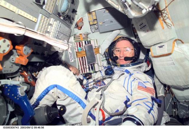 Astronaut Frank L. Culbertson, Expedition Three mission commander, wearing a Russian Sokol suit, is seated in the Soyuz spacecraft that is docked to the International Space Station (ISS). This Soyuz return vehicle will be moved from the Earth-facing port of the Zarya module for the linkup to the new Pirs Docking Compartment. The move of the Soyuz will mark the first time the new Pirs, which arrived at the station September 17, 2001, will serve as a docking port. The Soyuz will be shifted to prepare for the arrival of a new Soyuz return craft, to be launched October 21, 2001 from the Baikonur Cosmodrome in Kazakhstan. The Soyuz can serve as a crew return vehicle at the station for a maximum of about six months. This image was taken with a digital still camera.