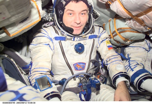 Cosmonaut Vladimir N. Dezhurov, Expedition Three flight engineer, wearing a Russian Sokol suit, is seated in the Soyuz spacecraft that is docked to the International Space Station (ISS). This Soyuz return vehicle will be moved from the Earth-facing port of the Zarya module for the linkup to the new Pirs Docking Compartment. The move of the Soyuz will mark the first time the new Pirs, which arrived at the station September 17, 2001, will serve as a docking port. The Soyuz will be shifted to prepare for the arrival of a new Soyuz return craft, to be launched October 21, 2001 from the Baikonur Cosmodrome in Kazakhstan. The Soyuz can serve as a crew return vehicle at the station for a maximum of about six months. Dezhurov represents Rosaviakosmos. This image was taken with a digital still camera.
