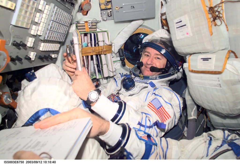 Astronaut Frank L. Culbertson, Expedition Three mission commander, and cosmonaut Vladimir N. Dezhurov (partially out of frame), flight engineer, wearing Russian Sokol suits, are seated in the Soyuz spacecraft that is docked to the International Space Station (ISS). This Soyuz return vehicle will be moved from the Earth-facing port of the Zarya module for the linkup to the new Pirs Docking Compartment. The move of the Soyuz will mark the first time the new Pirs, which arrived at the station September 17, 2001, will serve as a docking port. The Soyuz will be shifted to prepare for the arrival of a new Soyuz return craft, to be launched October 21, 2001 from the Baikonur Cosmodrome in Kazakhstan. The Soyuz can serve as a crew return vehicle at the station for a maximum of about six months. Dezhurov represents Rosaviakosmos. This image was taken with a digital still camera.