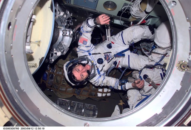 Astronaut Frank L. Culbertson, Expedition Three mission commander, wearing a Russian Sokol suit, is photographed in the Soyuz spacecraft that is docked to the International Space Station (ISS). This Soyuz return vehicle will be moved from the Earth-facing port of the Zarya module for the linkup to the new Pirs Docking Compartment. The move of the Soyuz will mark the first time the new Pirs, which arrived at the station September 17, 2001, will serve as a docking port. The Soyuz will be shifted to prepare for the arrival of a new Soyuz return craft, to be launched October 21, 2001 from the Baikonur Cosmodrome in Kazakhstan. The Soyuz can serve as a crew return vehicle at the station for a maximum of about six months. This image was taken with a digital still camera.