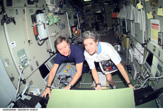 Astronaut Frank L. Culbertson, Jr. (left), Expedition Three mission commander, and French Flight Engineer Claudie Haignere, work in the Zvezda Service Module on the International Space Station (ISS). Haignere represents ESA, carrying out a flight program for CNES, the French Space Agency, under a commercial contract with the Russian Aviation and Space Agency. This image was taken with a digital still camera.