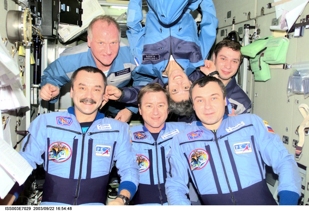 The Expedition Three crew (bottom) and the Soyuz Taxi crew assemble for a group photo in the Zvezda Service Module on the International Space Station (ISS). The Expedition Three crewmembers are astronaut Frank L. Culbertson, Jr. (center), mission commander, and cosmonauts Mikhail Tyurin (left) and Vladimir N. Dezhurov, both flight engineers. The Soyuz Taxi crewmembers are Commander Victor Afanasyev (left), French Flight Engineer Claudie Haignere, and Flight Engineer Konstantin Kozeev. Tyurin, Dezhurov, Afanasyev, and Kozeev represent Rosaviakosmos. Haignere represents ESA, carrying out a flight program for CNES, the French Space Agency, under a commercial contract with the Russian Aviation and Space Agency. This image was taken with a digital still camera.