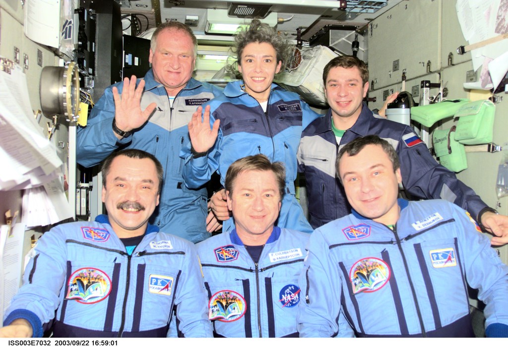The Expedition Three crew (bottom) and the Soyuz Taxi crew assemble for a group photo in the Zvezda Service Module on the International Space Station (ISS). The Expedition Three crewmembers are astronaut Frank L. Culbertson, Jr. (center), mission commander, and cosmonauts Mikhail Tyurin (left) and Vladimir N. Dezhurov, both flight engineers. The Soyuz Taxi crewmembers are Commander Victor Afanasyev (left), French Flight Engineer Claudie Haignere, and Flight Engineer Konstantin Kozeev. Tyurin, Dezhurov, Afanasyev, and Kozeev represent Rosaviakosmos. Haignere represents ESA, carrying out a flight program for CNES, the French Space Agency, under a commercial contract with the Russian Aviation and Space Agency. This image was taken with a digital still camera.