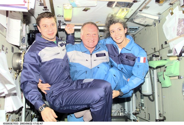 The Soyuz Taxi crewmembers assemble for a group photo in the Zvezda Service Module on the International Space Station (ISS). From the left are Flight Engineer Konstantin Kozeev, Commander Victor Afanasyev, and French Flight Engineer Claudie Haignere. Afanasyev and Kozeev represent Rosaviakosmos, and Haignere represents ESA, carrying out a flight program for CNES, the French Space Agency, under a commercial contract with the Russian Aviation and Space Agency. This image was taken with a digital still camera.