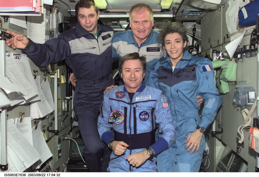 Astronaut Frank L. Culbertson, Jr. (foreground), Expedition Three mission commander, and the Soyuz Taxi crewmembers assemble for a group photo in the Zvezda Service Module on the International Space Station (ISS). From the left are Flight Engineer Konstantin Kozeev, Commander Victor Afanasyev, and French Flight Engineer Claudie Haignere. Afanasyev and Kozeev represent Rosaviakosmos, and Haignere represents ESA, carrying out a flight program for CNES, the French Space Agency, under a commercial contract with the Russian Aviation and Space Agency. This image was taken with a digital still camera.