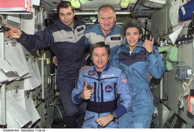Astronaut Frank L. Culbertson, Jr. (foreground), Expedition Three mission commander, and the Soyuz Taxi crewmembers assemble for a group photo in the Zvezda Service Module on the International Space Station (ISS). From the left are Flight Engineer Konstantin Kozeev, Commander Victor Afanasyev, and French Flight Engineer Claudie Haignere. Afanasyev and Kozeev represent Rosaviakosmos, and Haignere represents ESA, carrying out a flight program for CNES, the French Space Agency, under a commercial contract with the Russian Aviation and Space Agency. This image was taken with a digital still camera.