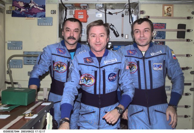 Astronaut Frank L. Culbertson, Jr. (center), Expedition Three mission commander, flanked by cosmonauts Mikhail Tyurin and Vladimir N. Dezhurov, both flight engineers, assemble for a group photo in the Zvezda Service Module on the International Space Station (ISS). Tyurin and Dezhurov represent Rosaviakosmos. This image was taken with a digital still camera.