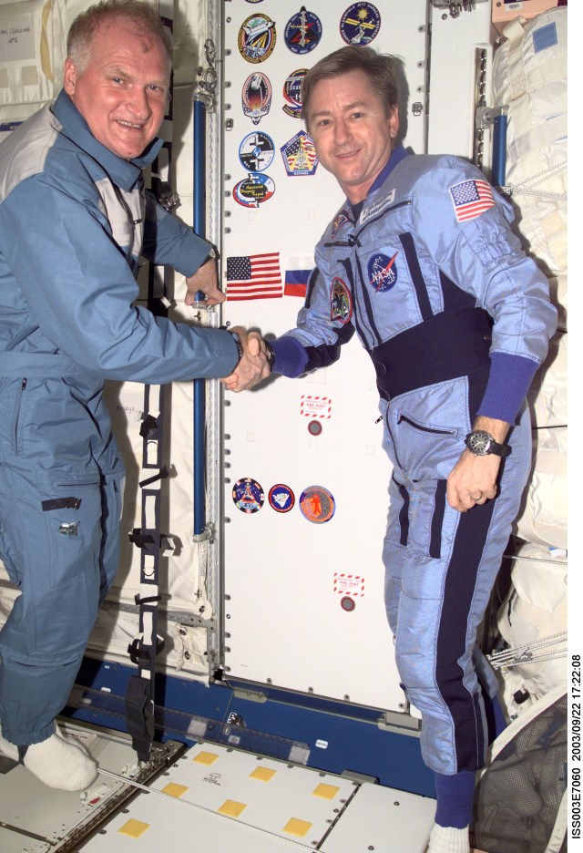 ISS003-E-7060 (23-31 October 2001) --- Astronaut Frank L. Culbertson, Jr. (right), Expedition Three mission commander, shakes hands with Soyuz Taxi crew Commander Victor Afanasyev in the Unity node on the International Space Station (ISS). Afanasyev represents Rosaviakosmos. This image was taken with at digital still camera.