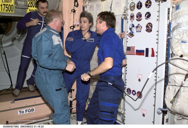 Soyuz Taxi crew Commander Victor Afanasyev (left foreground) and French Flight Engineer Claudie Haignere, along with astronaut Frank L. Culbertson, Jr., Expedition Three mission commander, and cosmonaut Mikhail Tyurin (background), flight engineer, are photographed in the Unity node on the International Space Station (ISS). Afanasyev represents Rosaviakosmos, and Haignere represents ESA, carrying out a flight program for CNES, the French Space Agency, under a commercial contract with the Russian Aviation and Space Agency. This image was taken with a digital still camera.